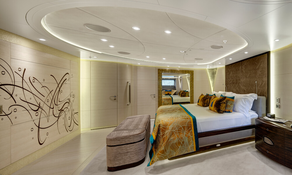 Complex geometries - after Luxurious yacht bedroom featuring a large bed with patterned bedding, mirrored headboard, abstract wall art, and recessed lighting, designed using marine panel fasteners.