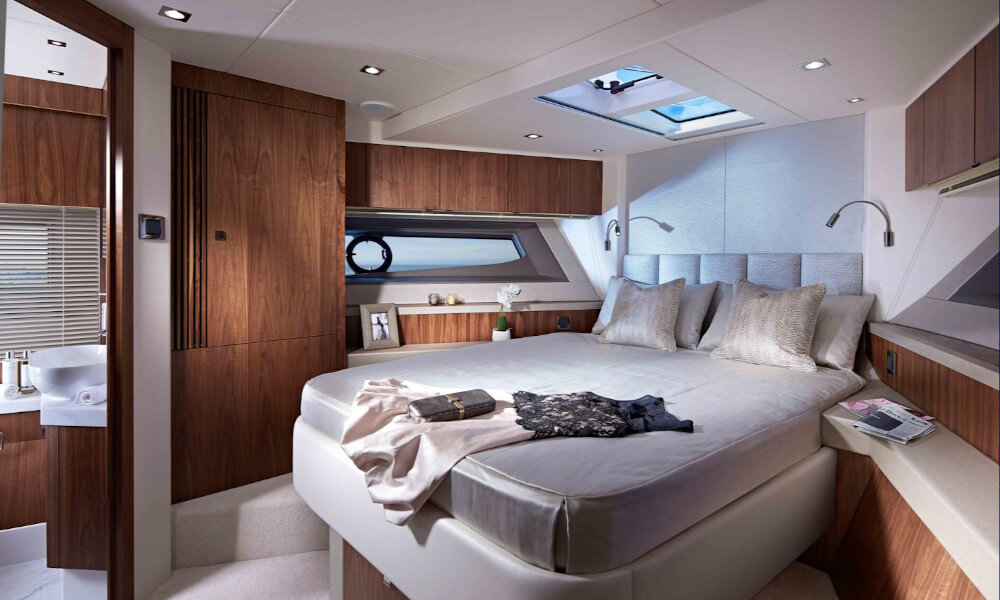 Upholstered panels - after Luxurious master stateroom in a Sunseeker Manhattan 52 yacht featuring a large bed, wooden cabinetry, and natural lighting from a skylight, showcasing refined interior design supported by marine panel fasteners.